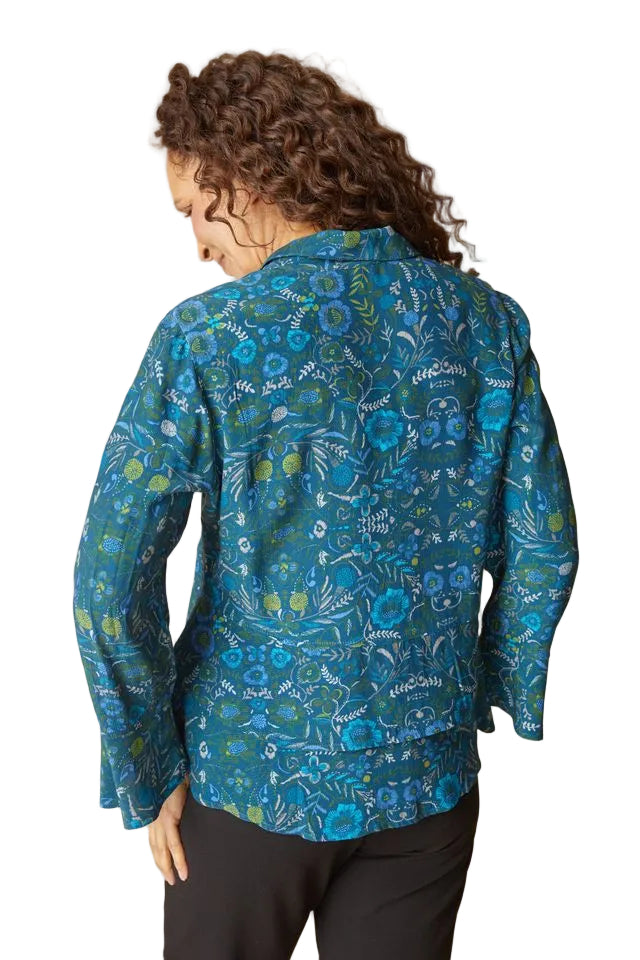Woman wearing a blue patterned shirt against a beige background