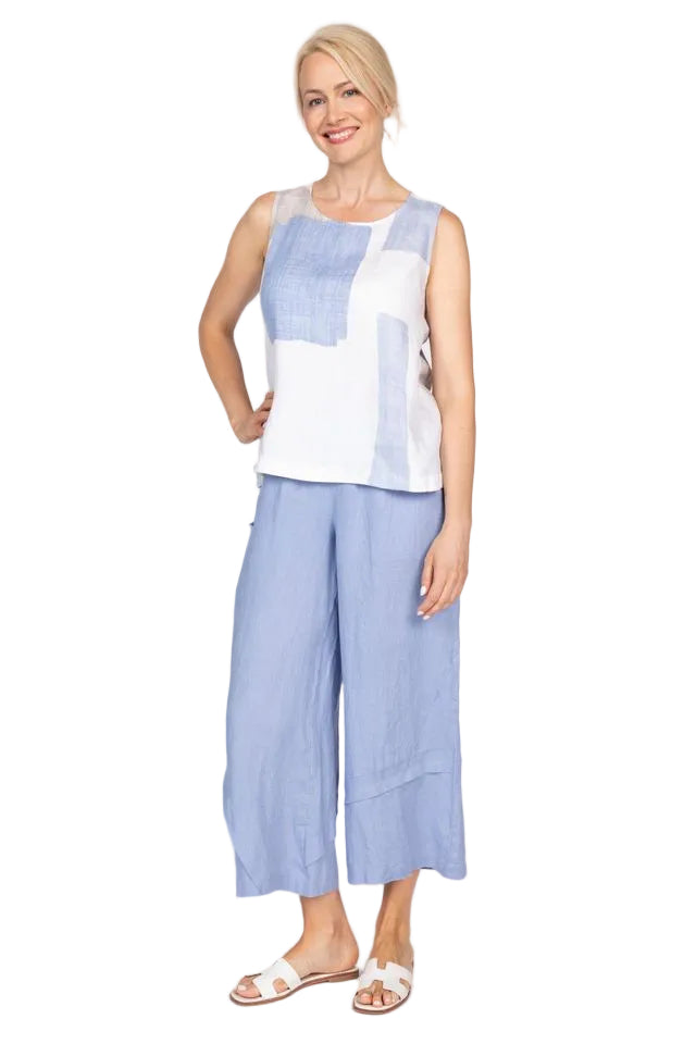 Woman wearing a sleeveless top with blue and white geometric pattern on a plain background